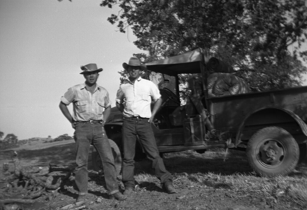 Black and white 1950s photo of Robert Connolly (left) with another man, in front of a WW2 surplus weapons carrier (Dodge Power Wagon) on the ranch 